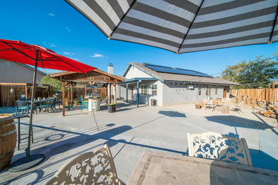 Patio dining table shaded by an outdoor umbrella - category image